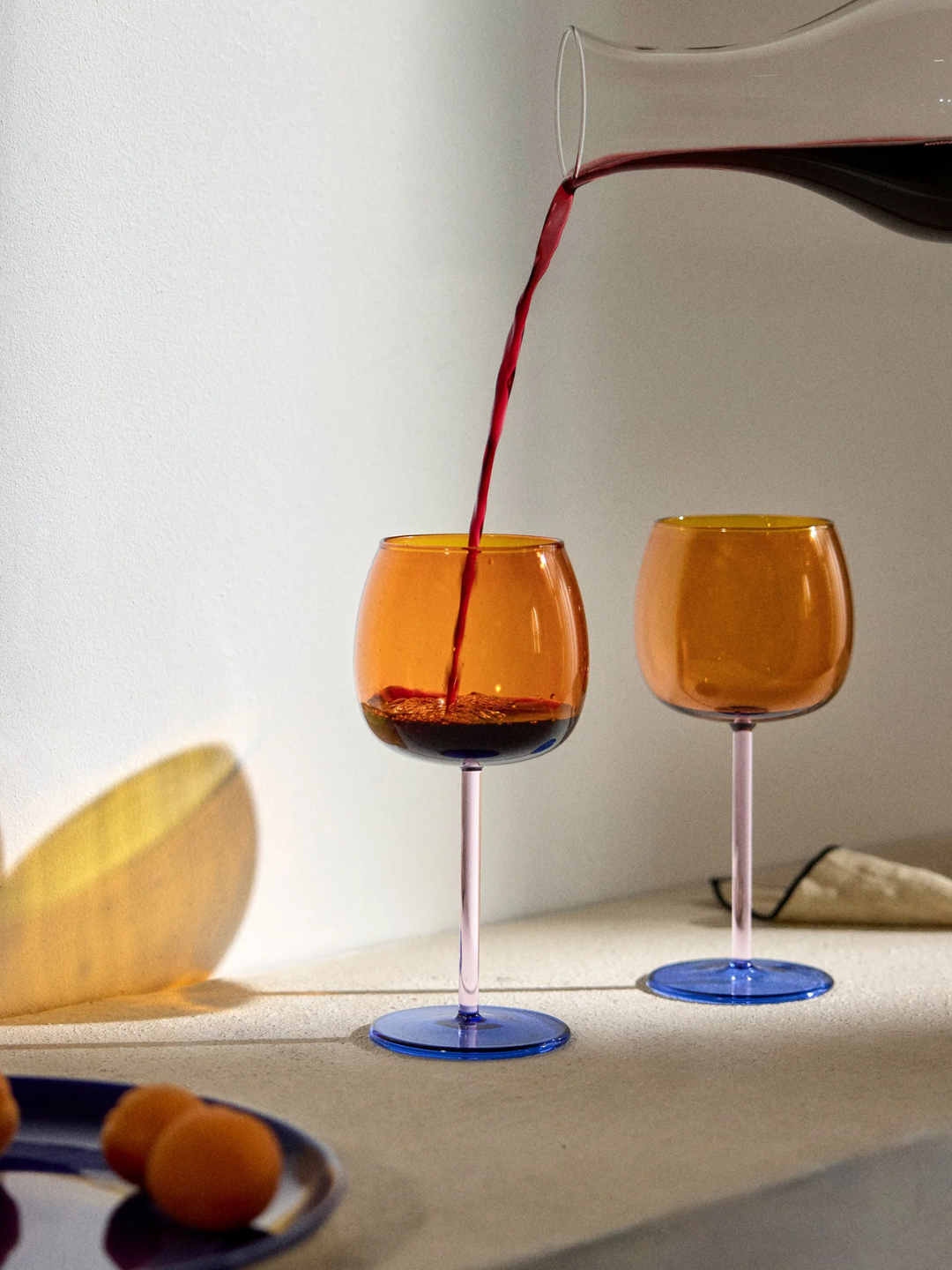 A pair of orange, pink, and blue wine glasses from Westwing