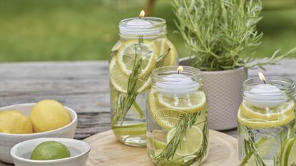 DIY bug repellents using lemon and lime in glass jars with a tealight holder