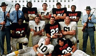 The Longest Yard Burt Reynolds and his teammates, flanked by armed guards
