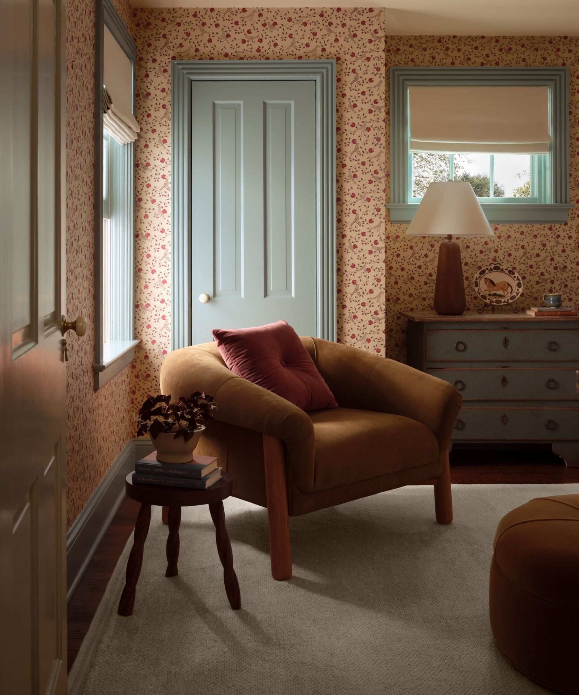 cozy wallpapered bedroom from the joon loloi fall 2025 collecton with blue painted woodwork and a cozy velvet arm chair