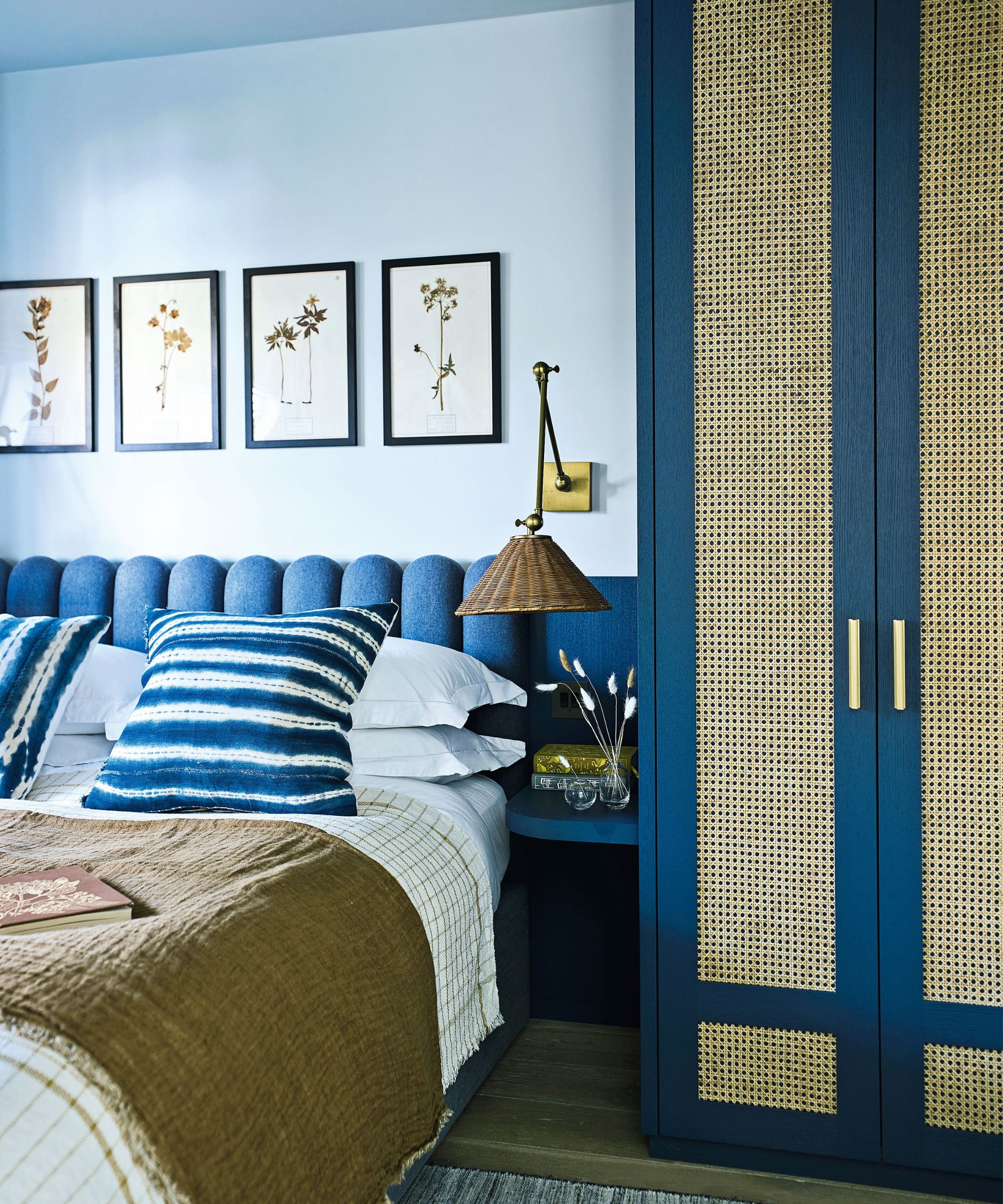 Blue bedroom with built in wardrobes with rattan fronts
