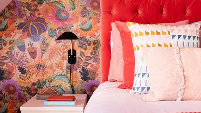 Bedroom with multicoloured walls, orange-red headboard, pink table and pink ceiling