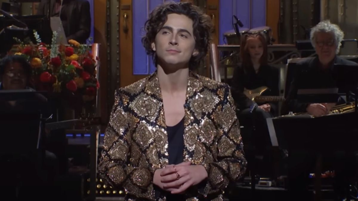 Timothee Chalamet during his monolouge on SNL holding his hands together with a percarious look on his face. 