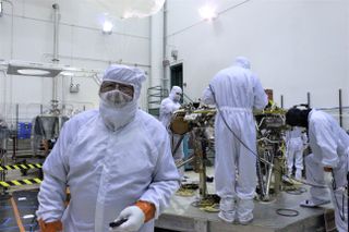 Space.com's Leonard David — suited up, complete with a beard mask — on the floor with NASA's Mars-bound InSight spacecraft.