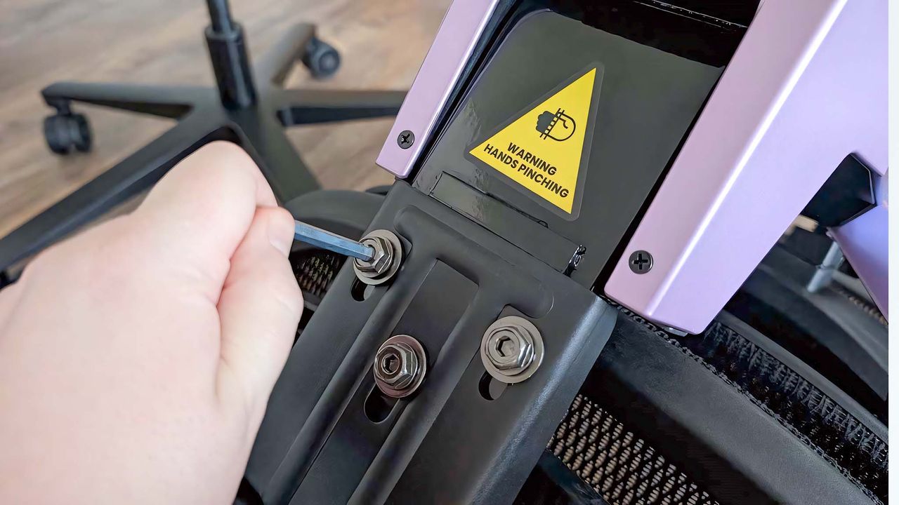 A hand assembling the adjusting back of the AndaSeat X-Air Pro Mesh Office Chair.