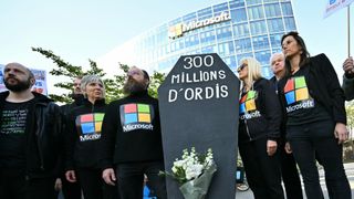 Demonstrators stage a protest to denounce the early retirement of 300 million computers, made obsolete by the forced upgrade from Windows 10 to Windows 11, in front of Microsoft France headquarters