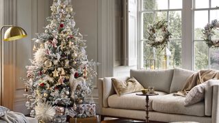 elegant neutral living room with snowy Christmas tree theme