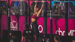 Aimee performing a pull up at a CrossFit competition