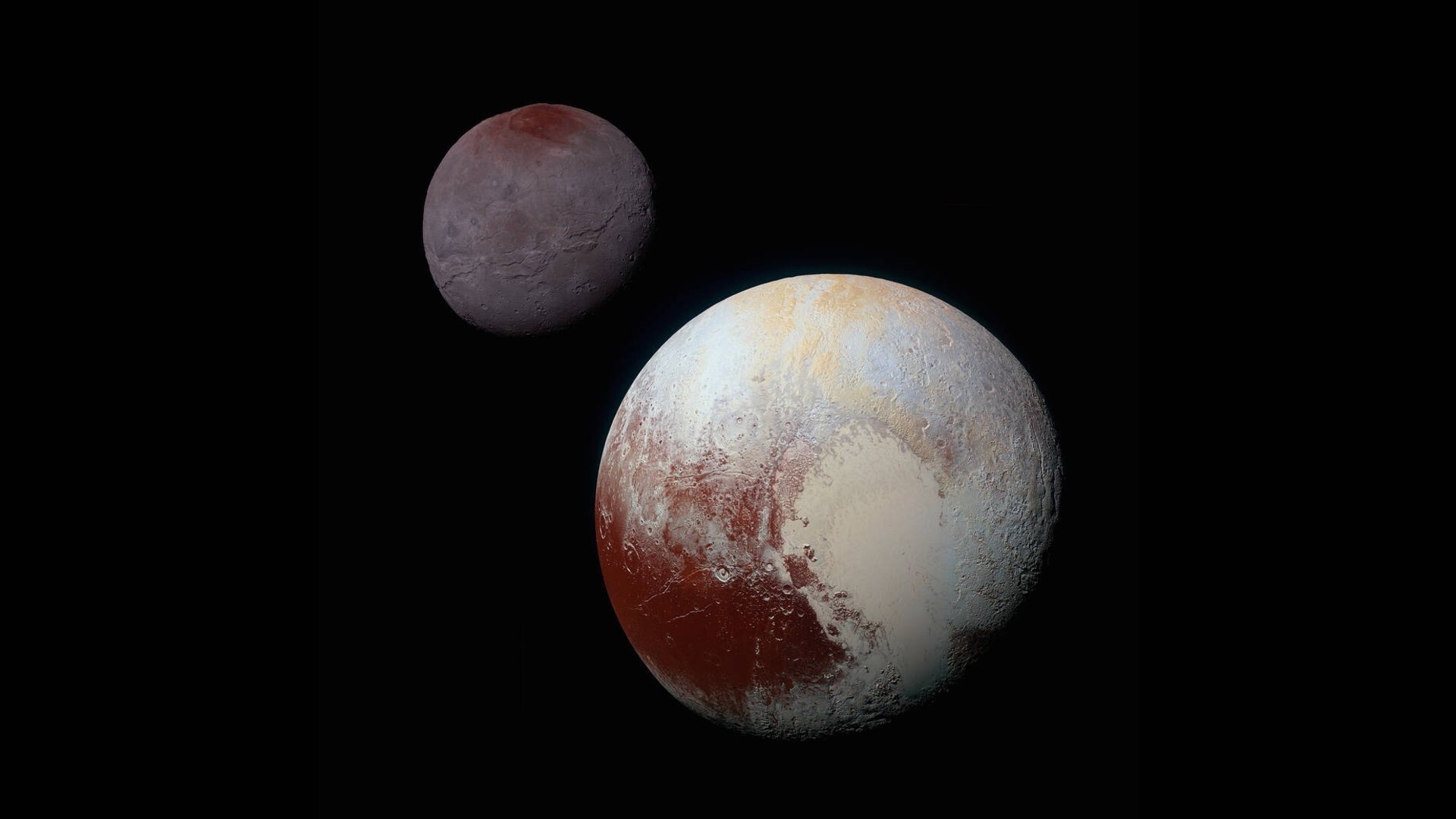 A close up of Pluto (a red and white planet in the front) and its moon Charon (a darker reddish sphere) in the back in the darkness of space