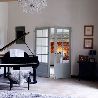 living area with white wall and french door and piano and wood floor