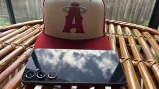 Galaxy A55 rear glass reflecting the sky while resting on a red hat
