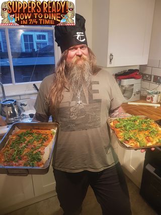 Ivar Bjornson in the kitchen holding two pizza pans