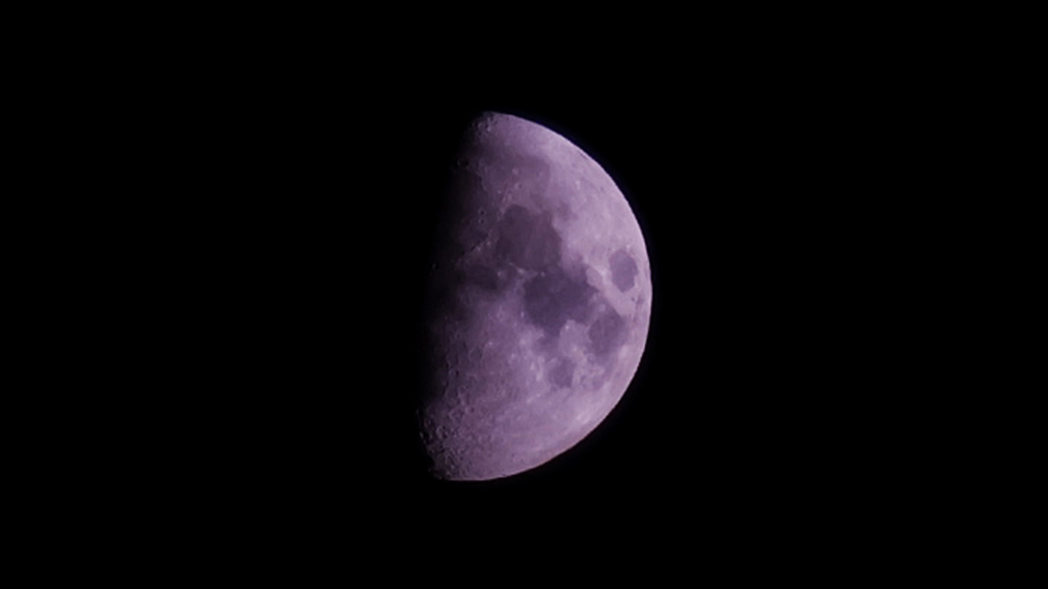A close-up view of a half-moon with lunar seas visible photographed by the Fujifilm GFX100S II.
