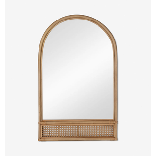 wooden tan arched mirror with a rattan panel at the bottom