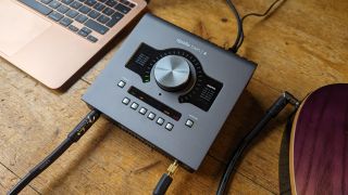 Close up of a Universal Audio Apollo Twin X audio interface on a wooden floor