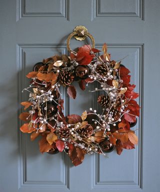 Leaf wreath with pine cones, berries, gold leaves, and baubles