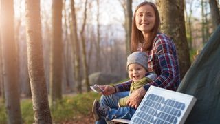 Solar battery on background of young family in forest