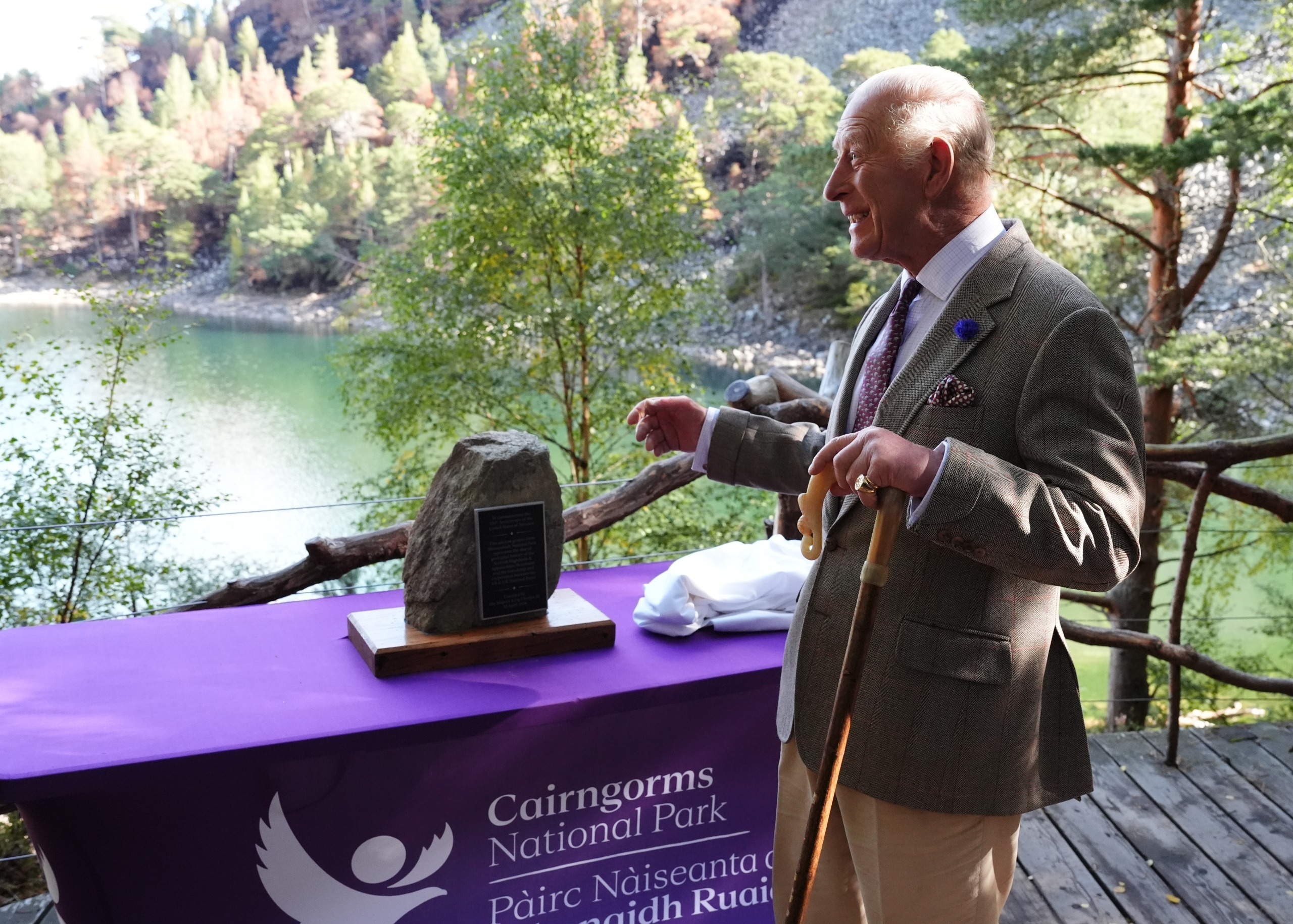 King Charles smiling in front of a table at Cairngorms National Park