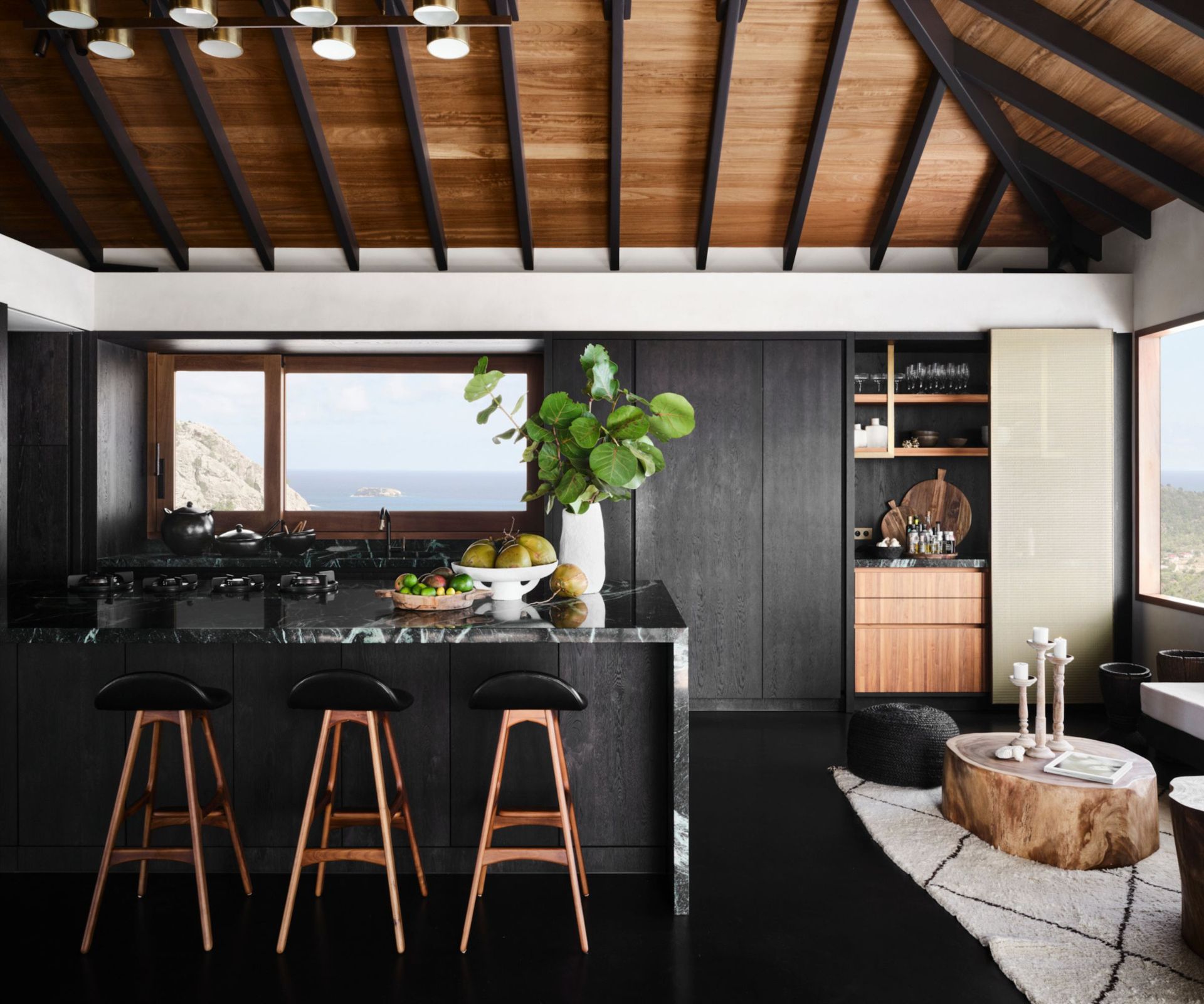 Moody kitchen with a black kitchen island topped with black and white marble