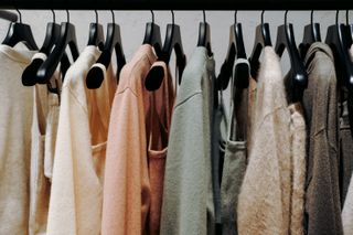 Clothes are neatly hung by color, systematization of clothes in closet