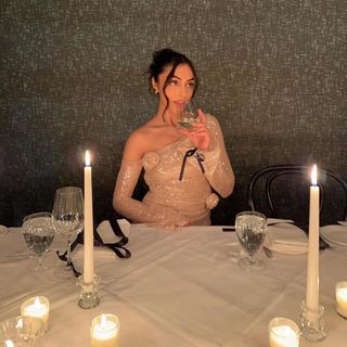 Woman sitting at a table with candles.