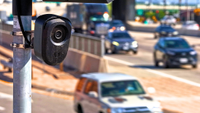 a Flock camera with a street in the background