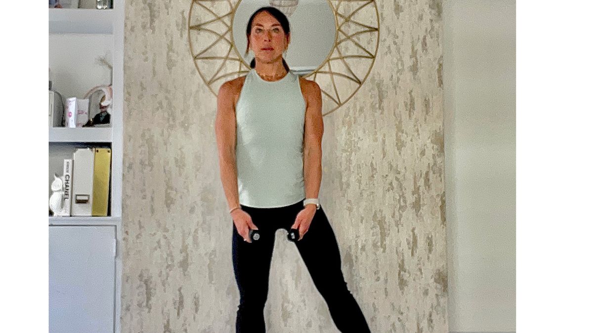 Lucy Miller performing dumbbell lateral raise with side leg lift at home