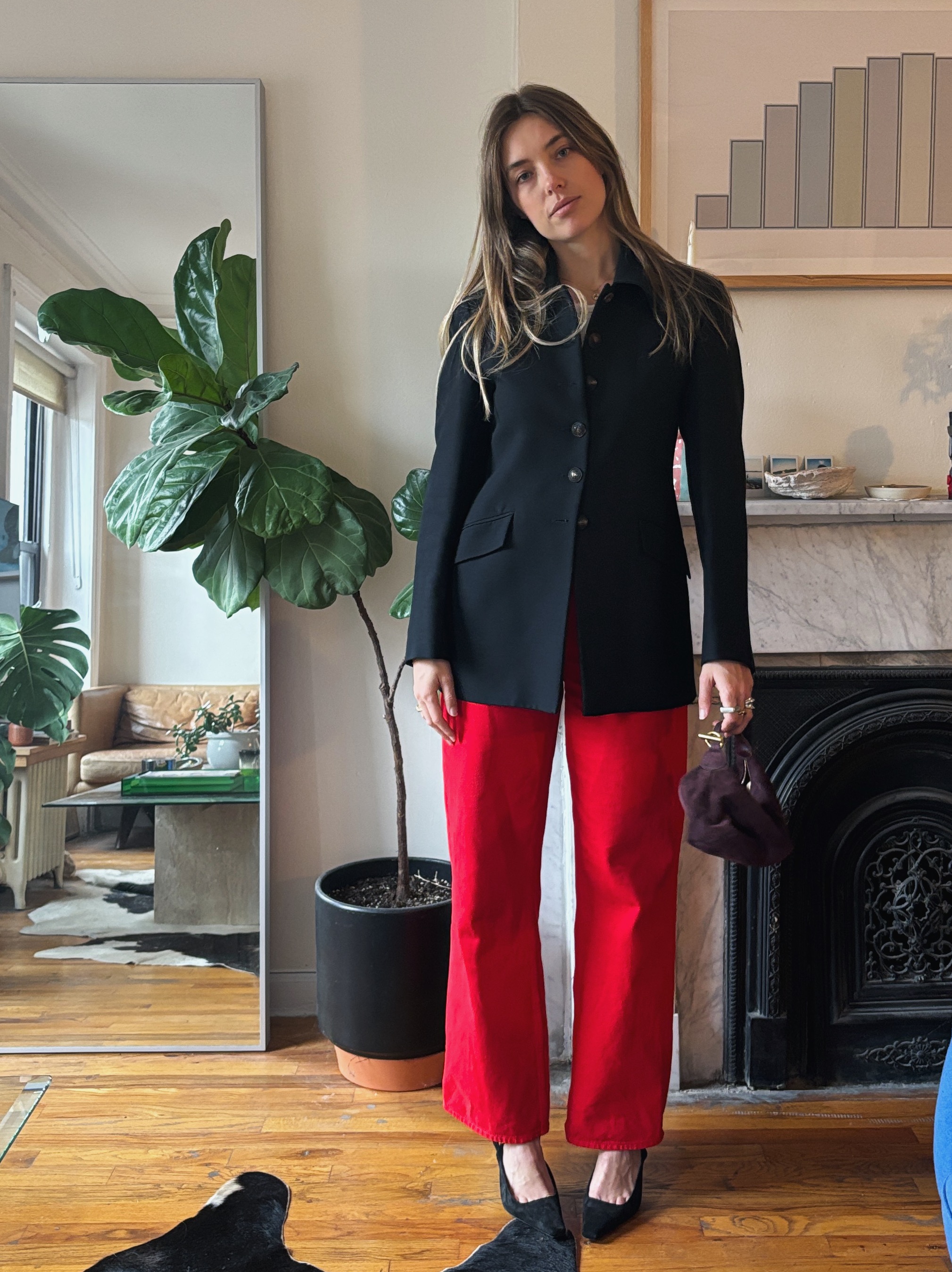 Aemilia Madden wearing a black blazer, red pants, and black shoes
