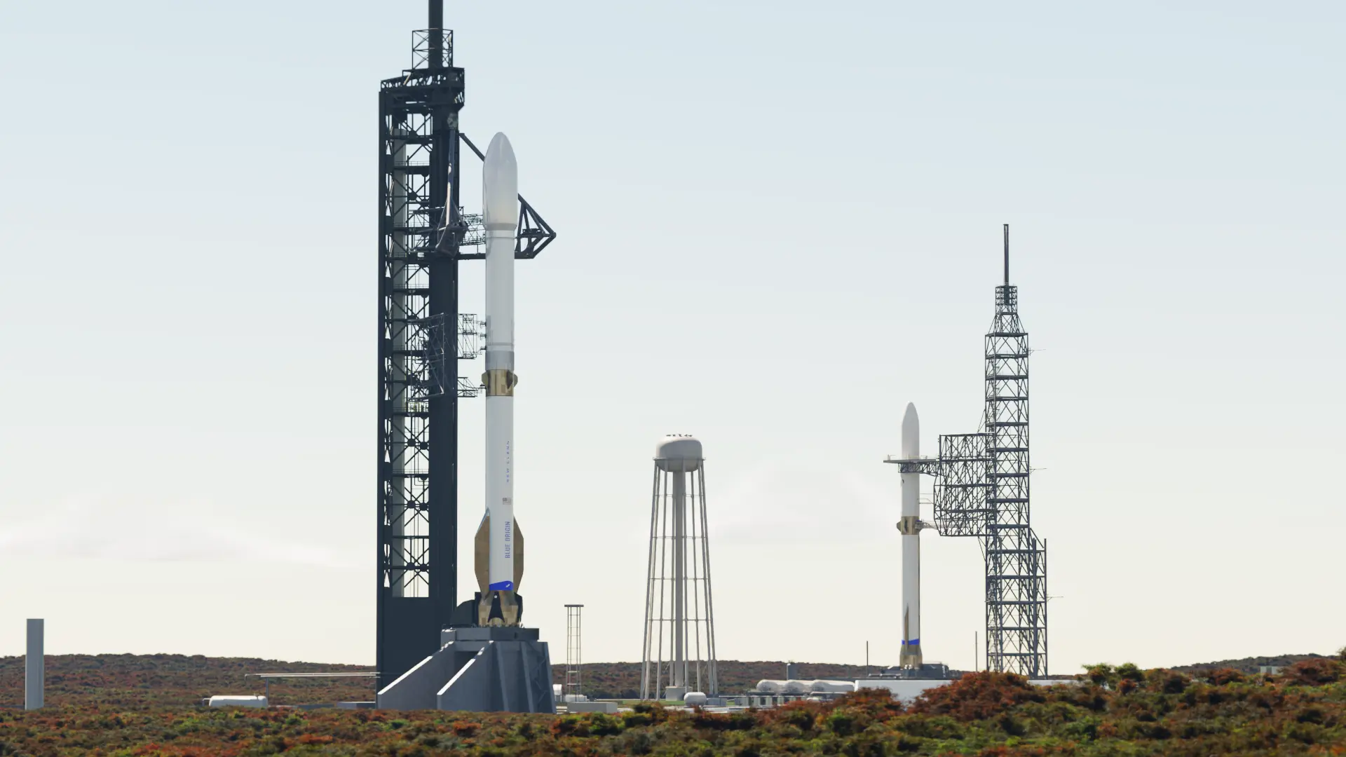 Two rockets stand at neighboring launch towers. 