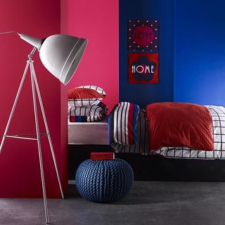 pink and blue bedroom with grey flooring and lamp light