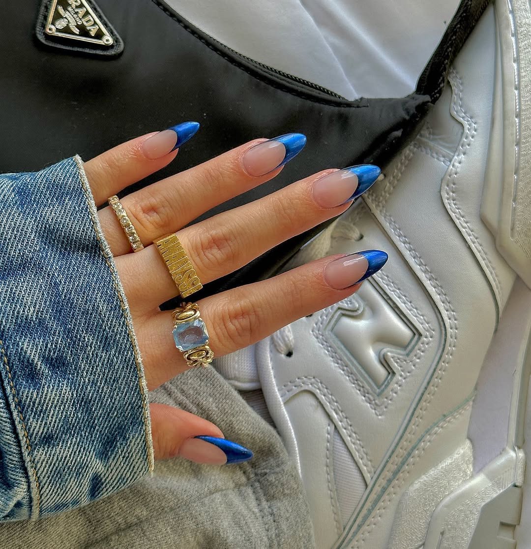 a person wearing a french manicure with blue chrome tips