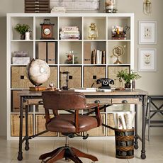 a neutral office with wooden desk white bookcase and a leather desk chair