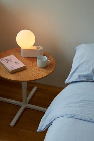 orb table lamp next to a grey bed