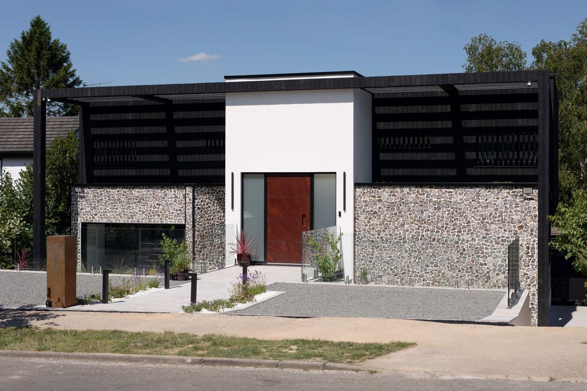 The exterior of the flint and black timber clad home