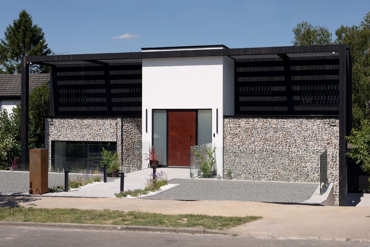 The exterior of the flint and black timber clad home