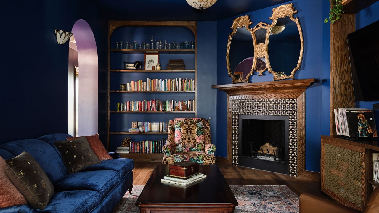 dark blue living room with wood fireplace and dark blue sofa 