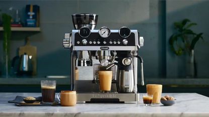 A De'Longhi La Specialista Maestro coffee maker in a modern kitchen surrounded by different types of coffee