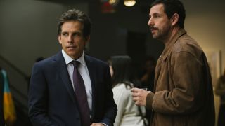 Ben Stiller and Adam Sandler standing together at a party in The Meyerowitz Stories (New and Selected).