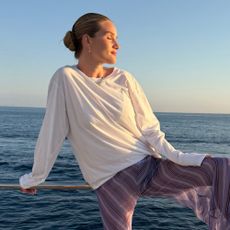 Model @rosiehw wears a white long-sleeve t-shirt with striped sheer trousers.