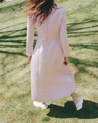 a model wears a pink sandy liang dress with white sandy liang x salmon mary janes