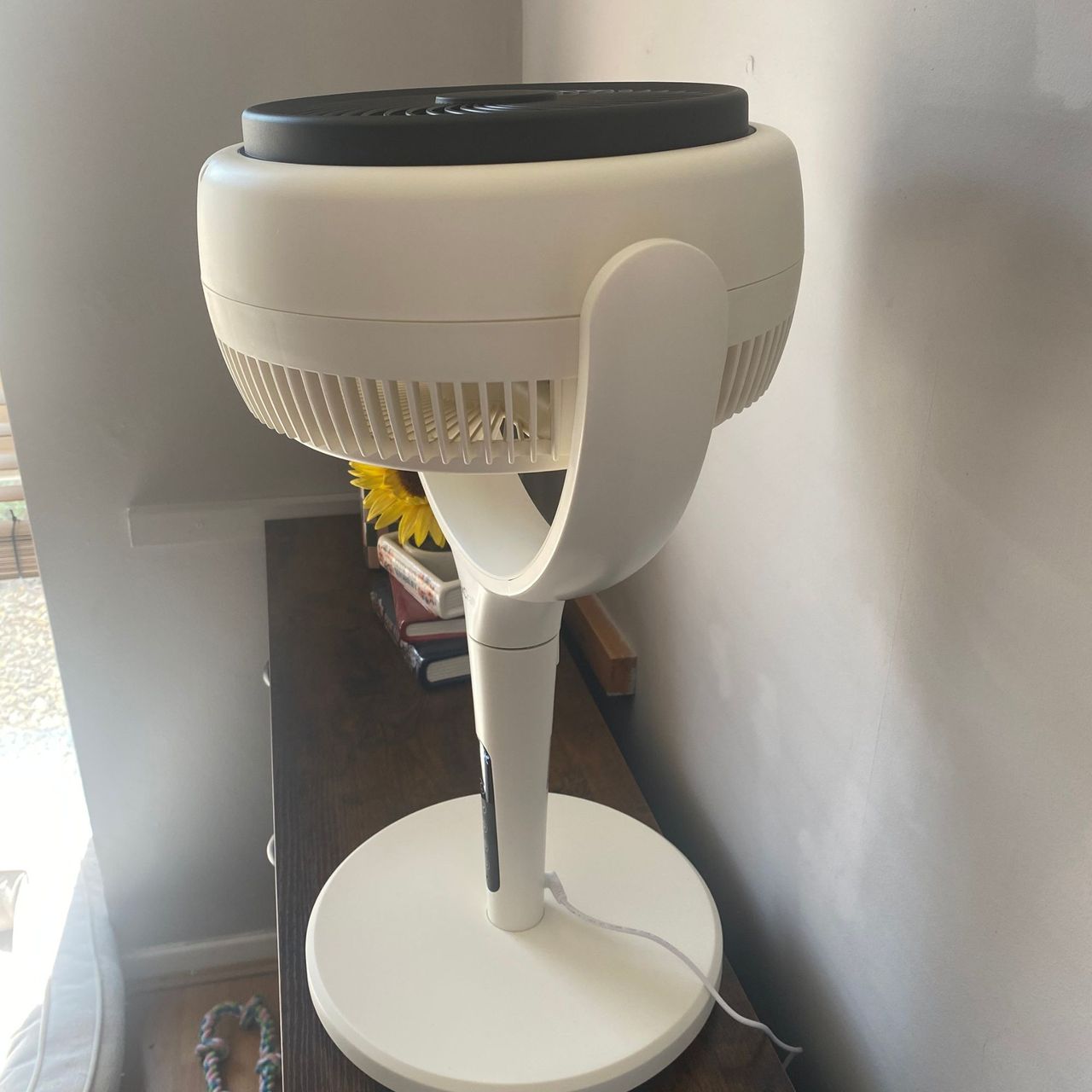 Maximum upwards tilt of the AirCraft LUME Quiet Air Circulator Fan on a wooden sideboard in a taupe coloured room