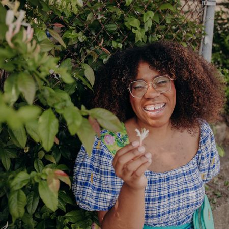 Urban forager Alexis Nelson in front of a bush