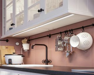 Integrated kitchen cabinet lighting in pink kitchen