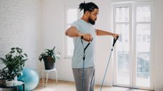 A man using the best resistance bands to perform lateral raises