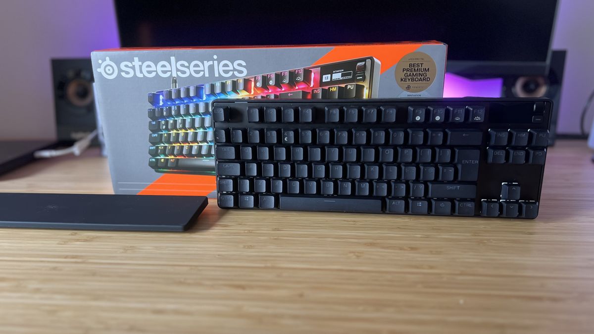 SteelSeries Apex Pro TKL Gen 3 keyboard with box and wrist rest on a wooden desk