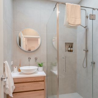 a modern bathroom with a wooden vanity and a shower