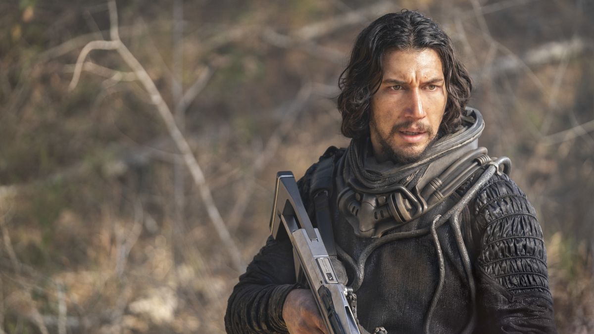 Mills (Adam Driver) holding a futuristic rifle in 65