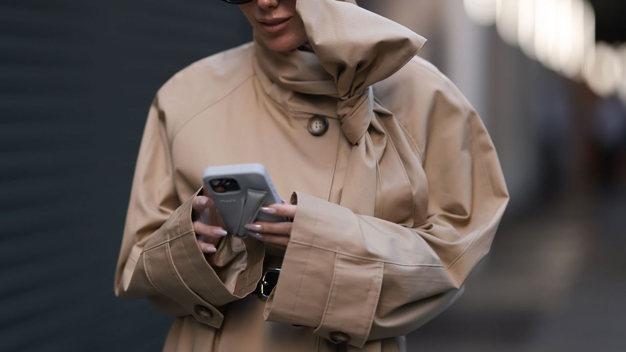 close up of a woman on her phone wearing a beige coat - Fresh start nails 