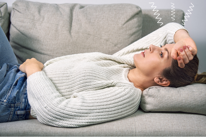 Woman lying on the sofa feeling sick after waking up in the morning