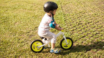 toddler is riding a bicycle outdoor - stock photo